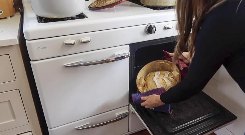 removing lid from dutch oven during the bread baking process