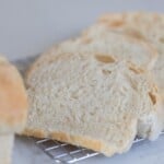 Slices of potato flake sourdough starter sandwich bread on a wire rack