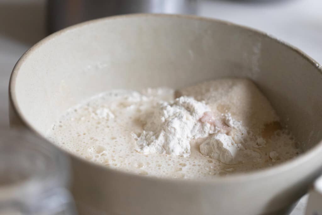 Large cream mixing bowl with sourdough beer bread ingredients inside 