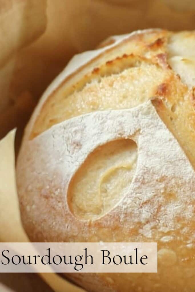 close up picture of a sourdough boule in a parchment lined dutch oven