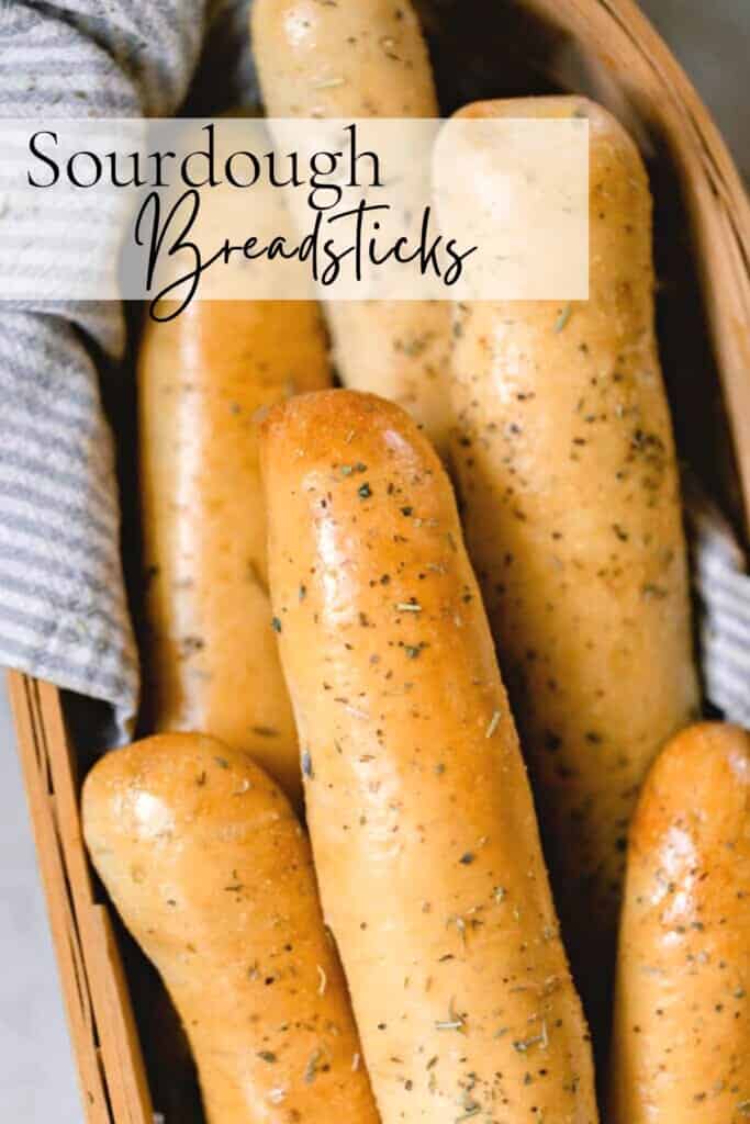 overhead photo of sourdough bread sticks in a towel lined basket