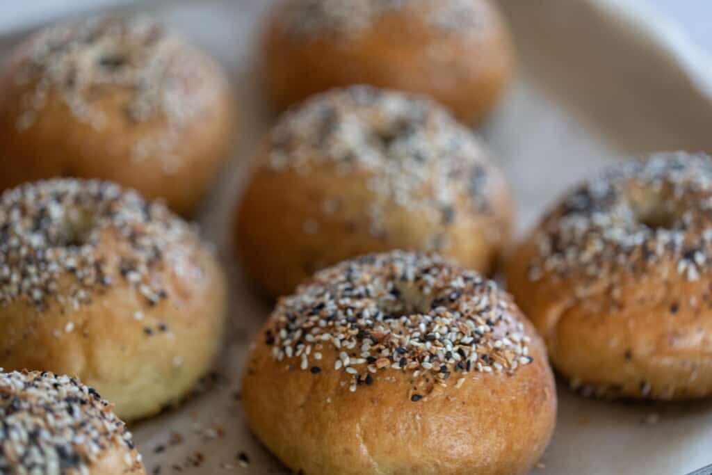 sourdough discard bagels topped with bagel seasoning on a parchment lined cookie sheet