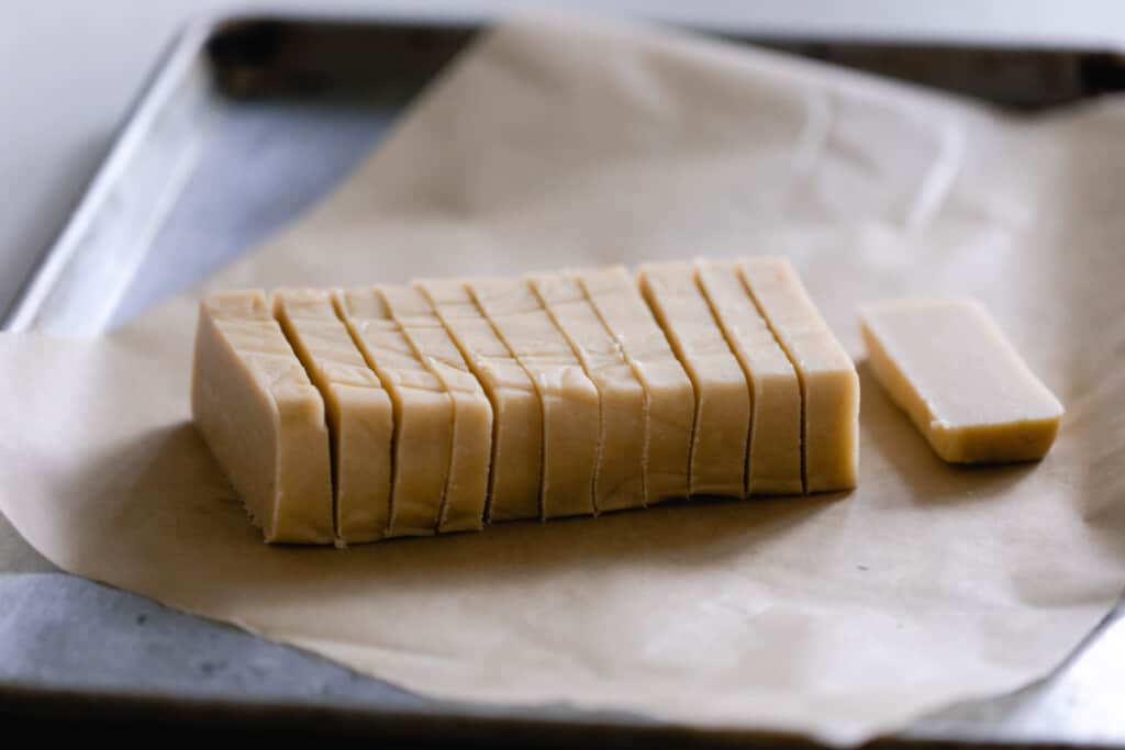 sourdough shortbread cookies cut into 1/2 inch thick cookies on a parchment paper lined baking sheet