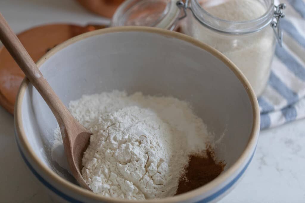 dry ingredients adding to a stoneware bowl