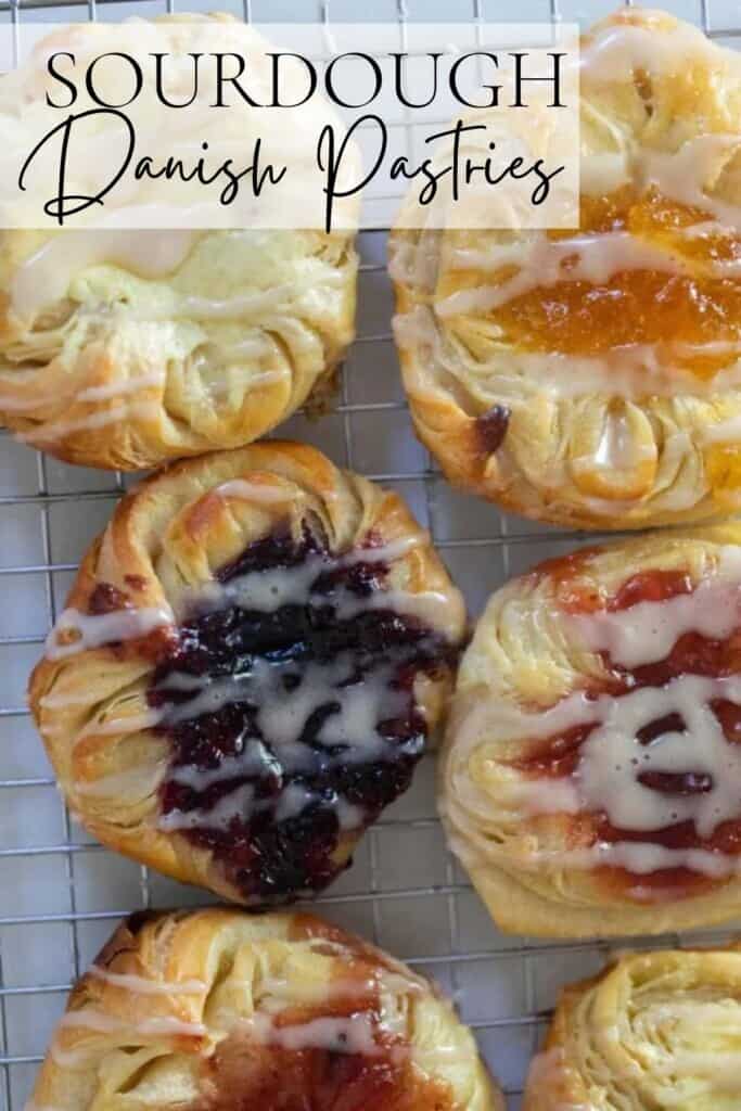 overhead photo of Danish sourdough pastries topped with cream cheese filling and jam and drizzled with a glaze on a wire rack