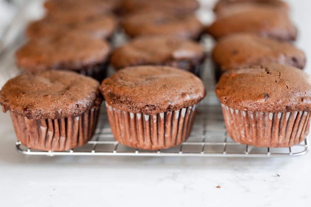 einkorn protein muffins lined up on a cooling rack on a white counter top