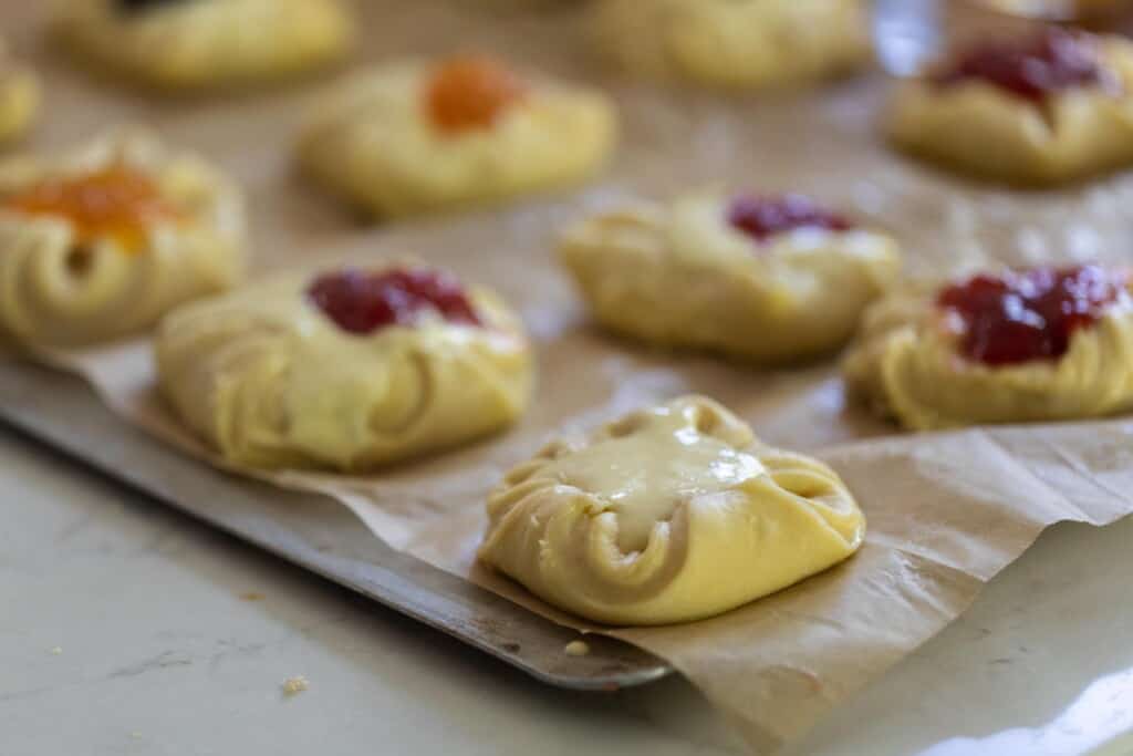unbaked sourdough pastries with filling on a parchment lined baking sheets