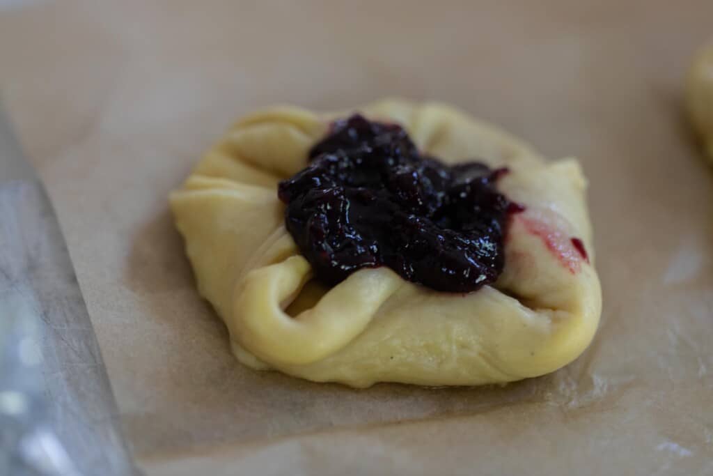 sourdough pastry dough shaped and a filling placed on top on parchment paper