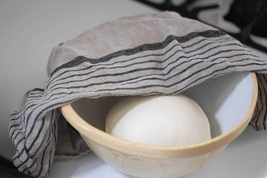 dough ball in a bowl with a towel