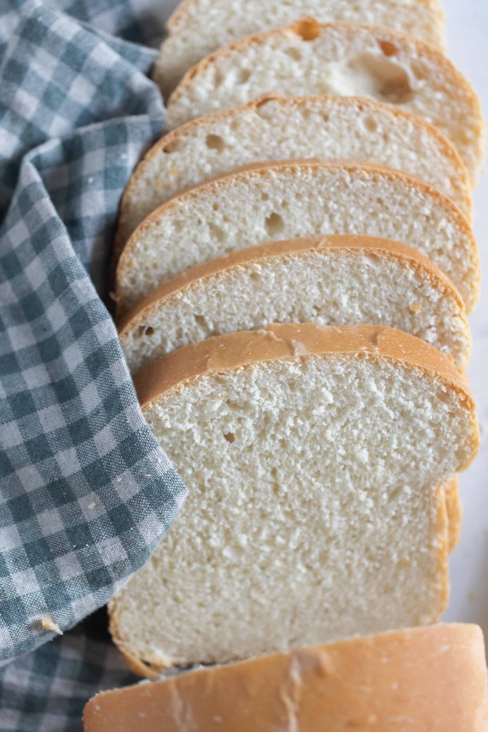 slices of sourdough buttermilk bread fanned out on a white and blue checked towel