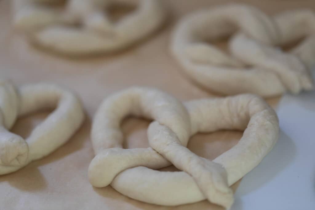 sourdough discard pretzels shaped on parchment paper