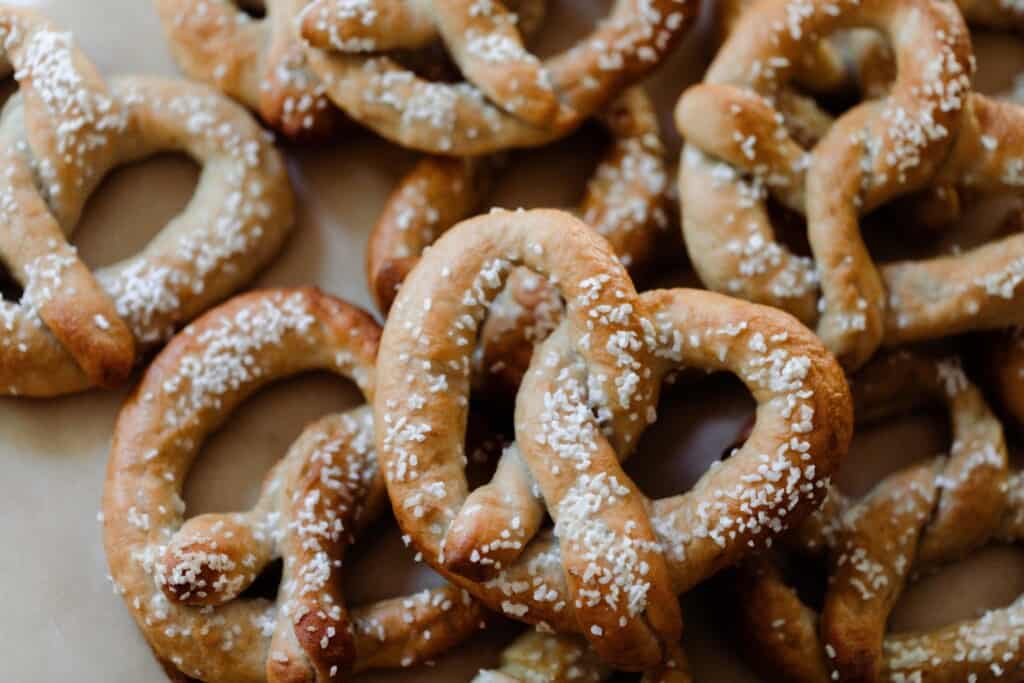 seven sourdough discard pretzels on parchment paper in two layers