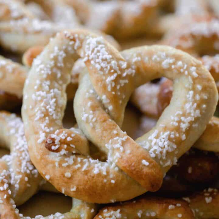 sourdough discard pretzels covered with course salt laying on a bed of pretzels