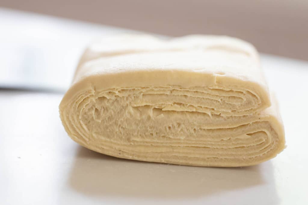 sourdough pastry dough folded up on a white countertop