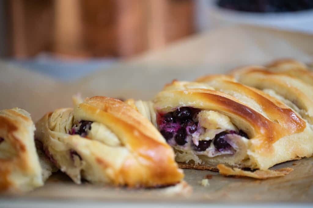 sourdough blueberry pastry braid sliced up on parchment paper