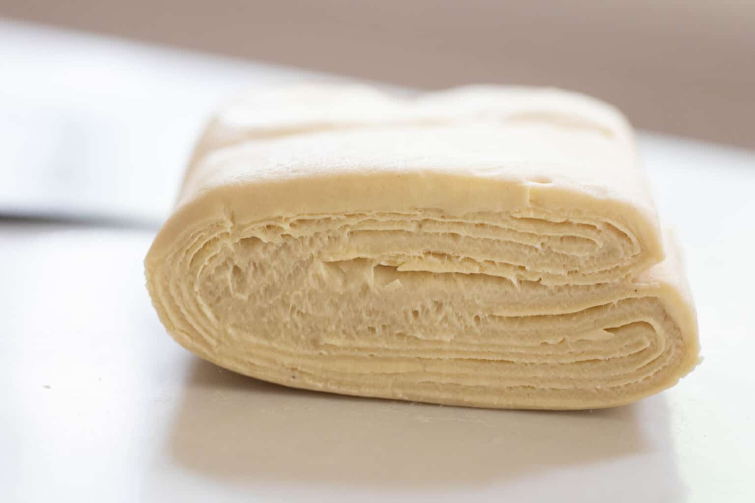sourdough pastry dough folded up on a white countertop