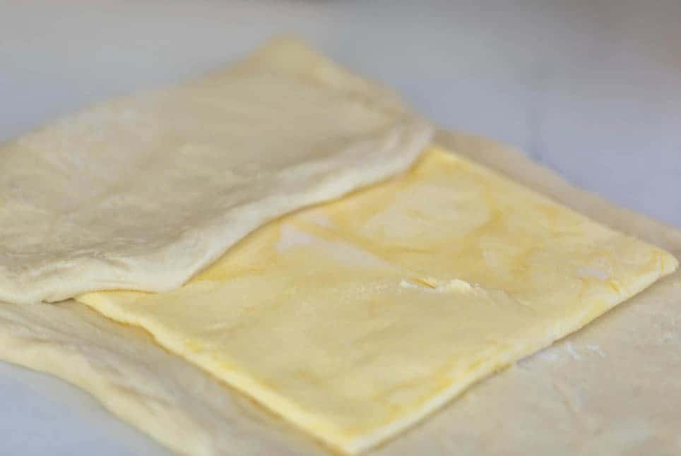 folding pastry dough over a rolled out rectangle of butter