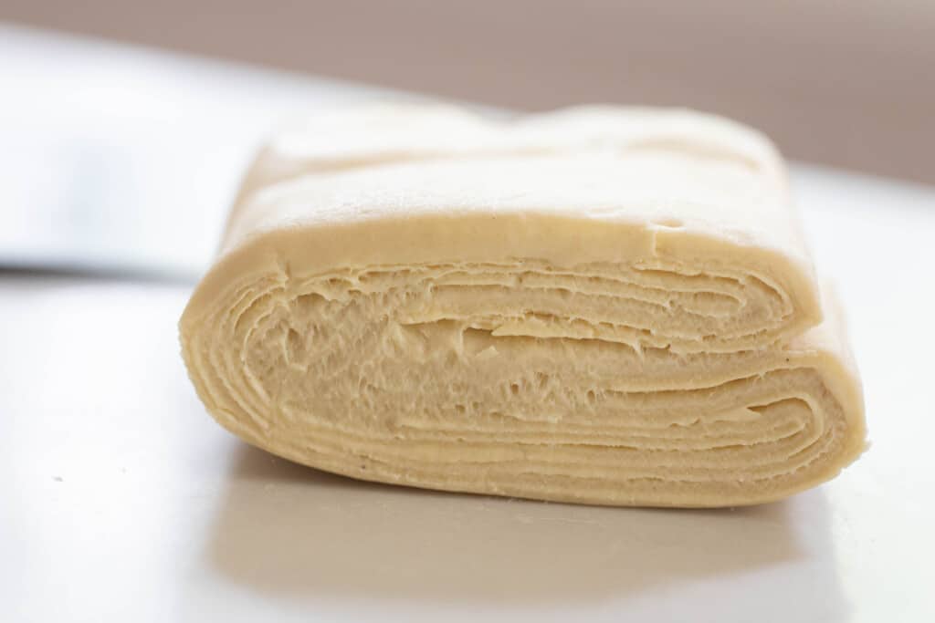 sourdough puff pastry folded up on a white countertop
