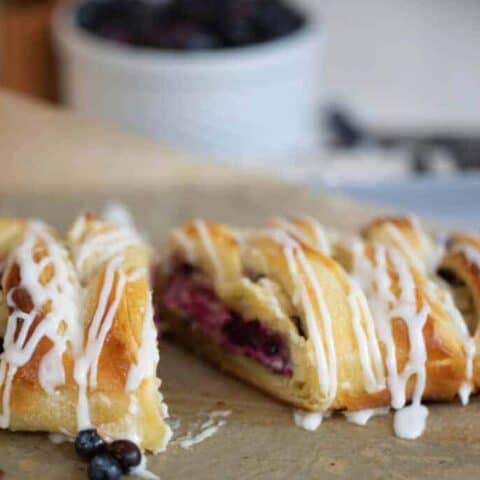 sourdough puff pastry braided with a cream cheese and blueberry filling on a baking sheet