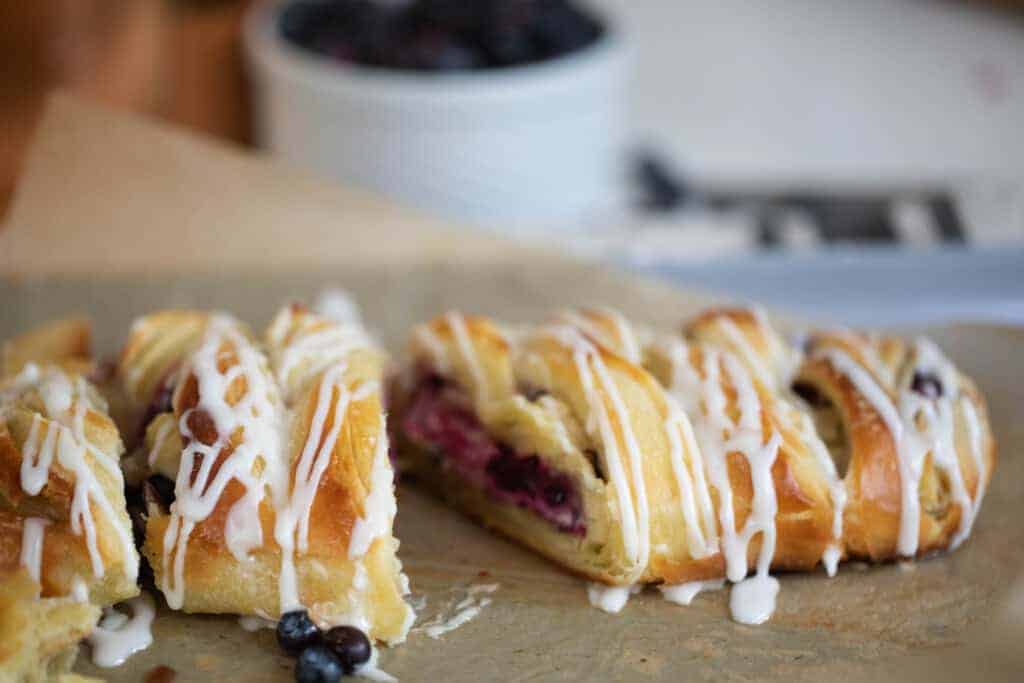 sourdough puff pastry braided with a cream cheese and blueberry filling on a baking sheet