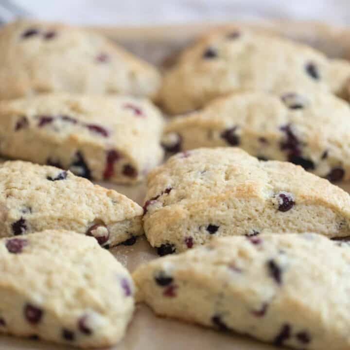 a baking pan lined with parchment paper with freshly baked blueberry sourdough scones