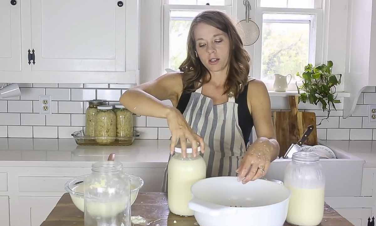 Adding lid to a jar of milk and kefir grains.