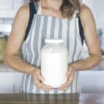 Woman holding a jar of milk kefir.