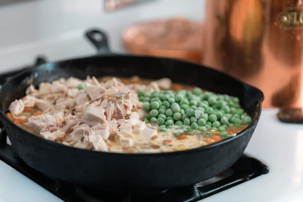 peas chicken, and vegetables in bone brown in a cast iron skillet