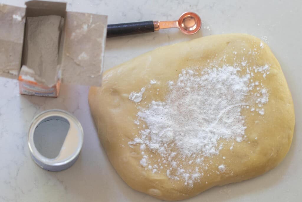 baking soda, baking powder, and salt added to the top of dough patted out on a white countertop