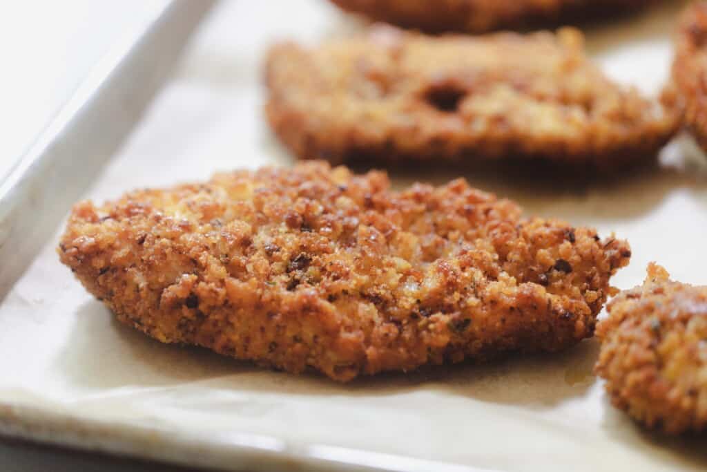 sourdough fried chicken on a parchment lined baking sheet