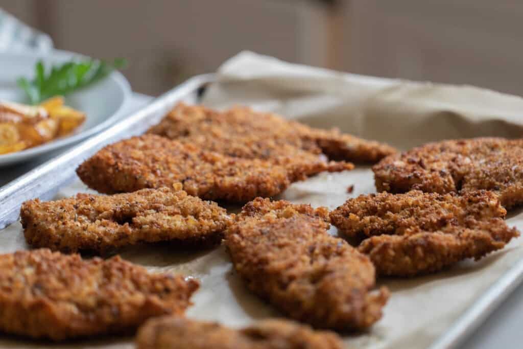 sourdough fried chicken on parchment lined backing sheet