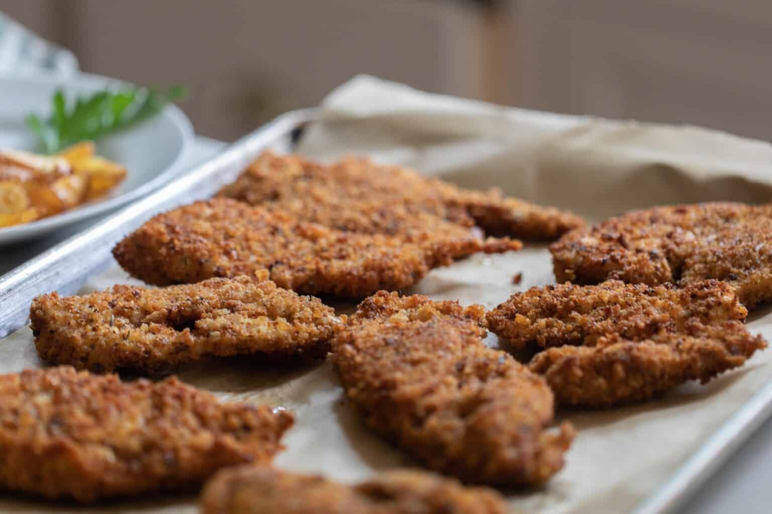 sourdough fried chicken on parchment lined backing sheet