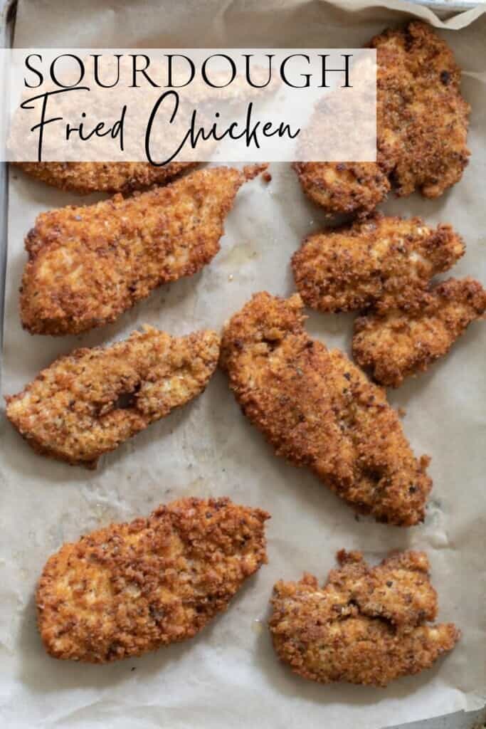 sourdough fried chicken on a parchment lined baking sheet