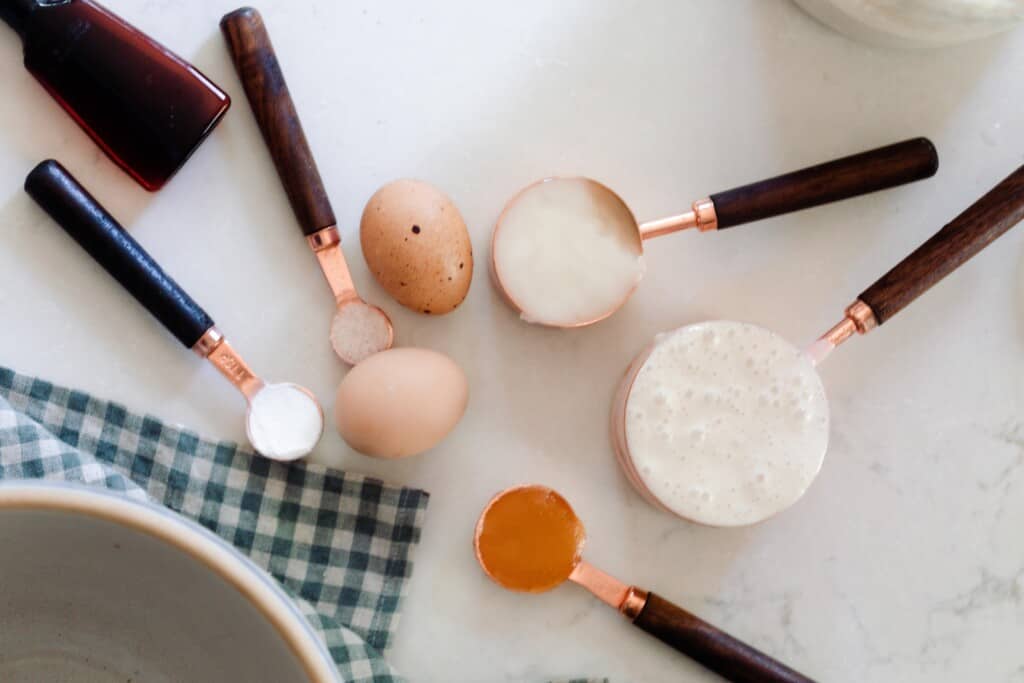 overhead photos of measuring cups and spoons full of ingredients, along with eggs on a white countertop
