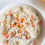 A bowl of creamy chicken and wild rice soup sitting on a countertop.