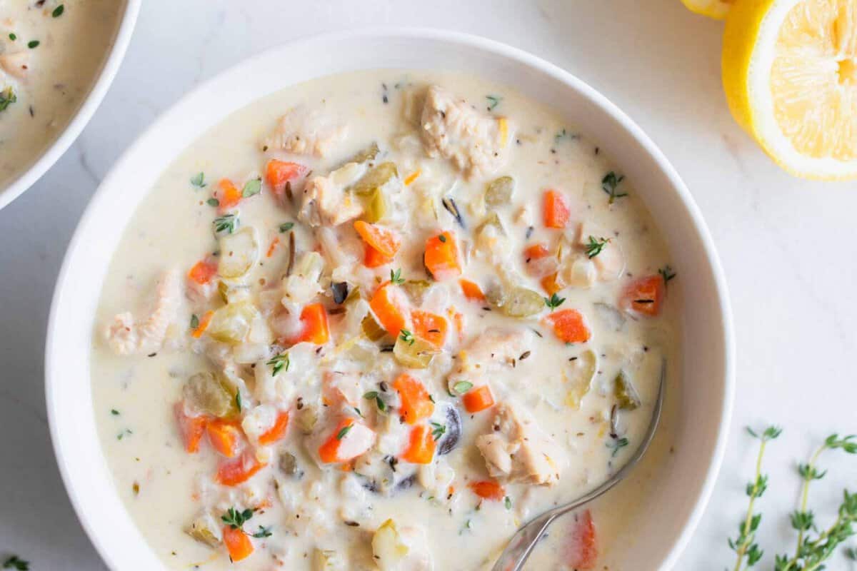 A bowl of creamy chicken and wild rice soup sitting on a countertop.