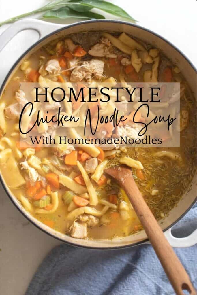 overhead photo of a white dutch oven full of homestyle chicken noodle soup with carrots with a wooden ladle in the pot