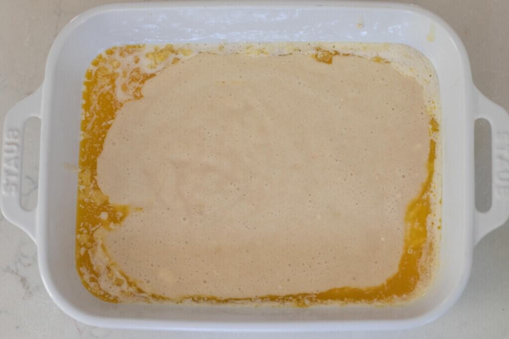 sourdough batter in a baking dish with melted butter