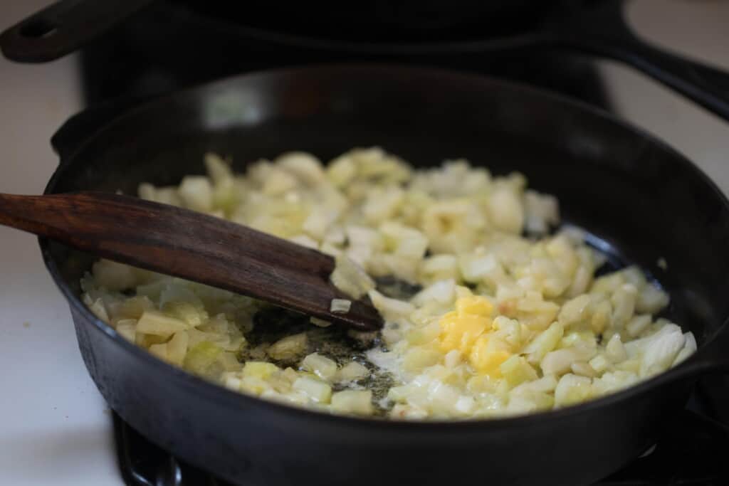 celery and onions sautéing in a skillet
