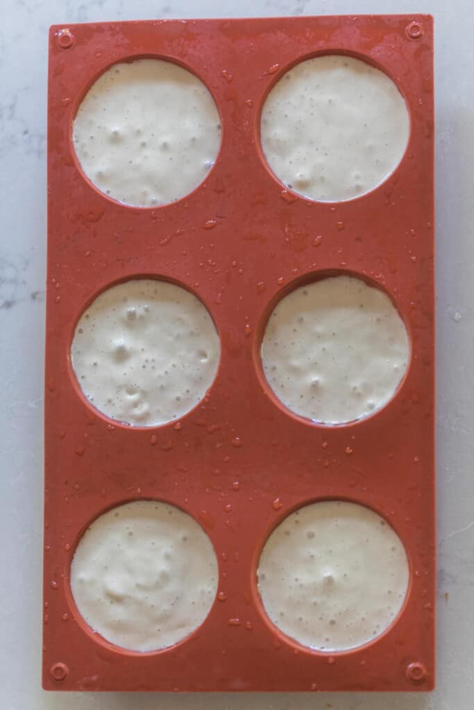 overhead photo of sourdough starter in a silicone muffin pan