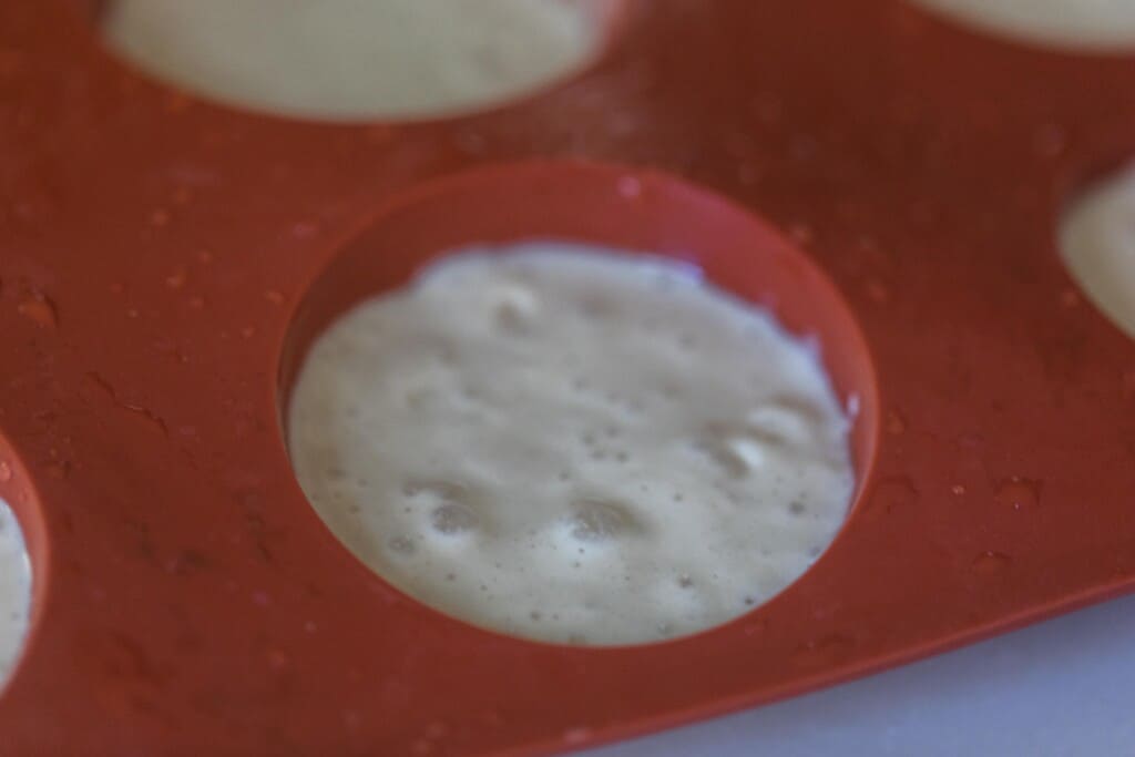 close up of sourdough starter in a silicone muffin pan