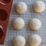 frozen sourdough starter disks on a wire rack with a silicon tray to the left