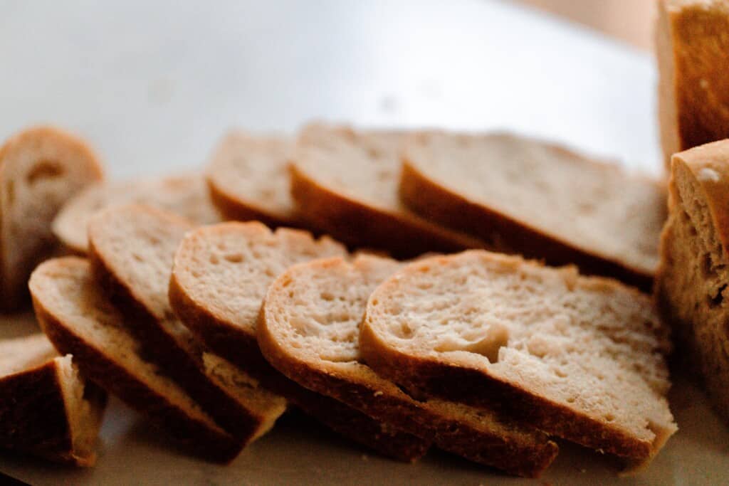 sourdough bread sliced on a wood cutting board on a white countertop