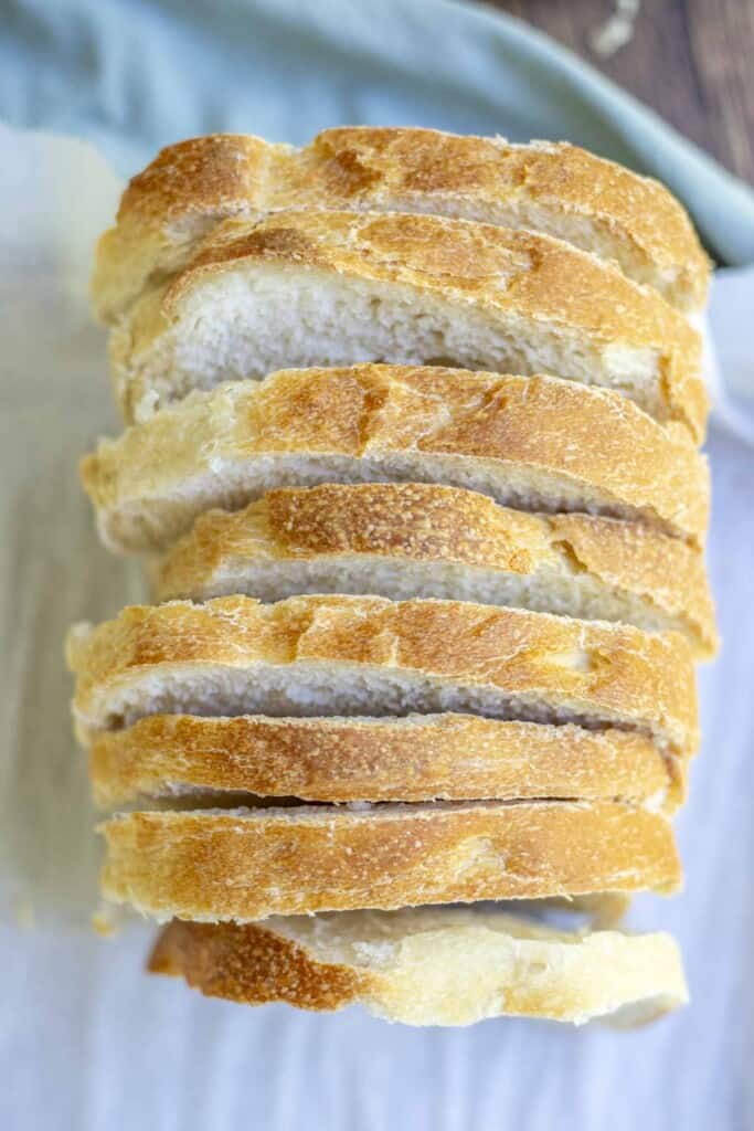 overhead photo of sourdough bread sliced up on parchment paper