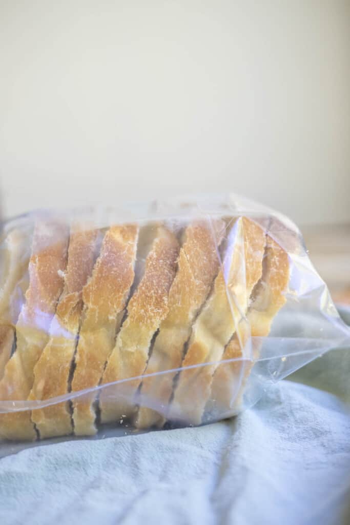frozen slices of sourdough bread in a ziplock bag on a green towel