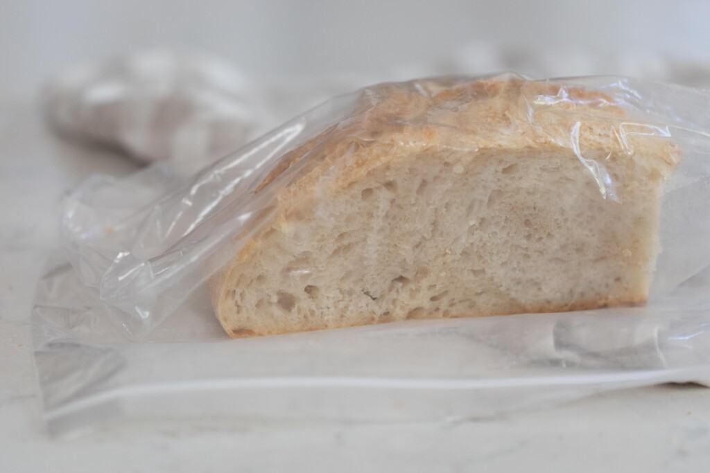 A cut into sourdough boule in a plastic bag