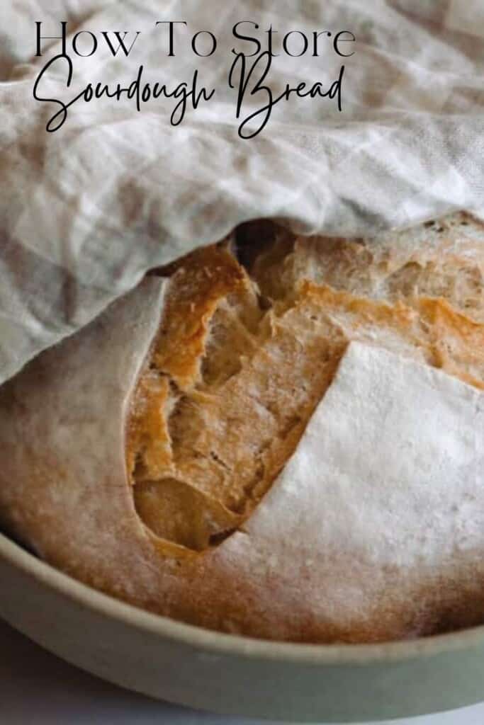 a close up photo of a sourdough boule in a bowl topped with a tan and white checked towel