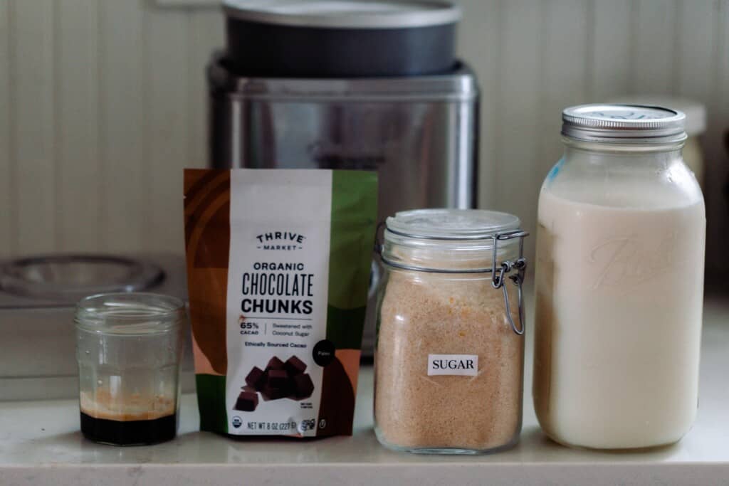 espresso, chocolate chips, sugar, and milk on a white countertop