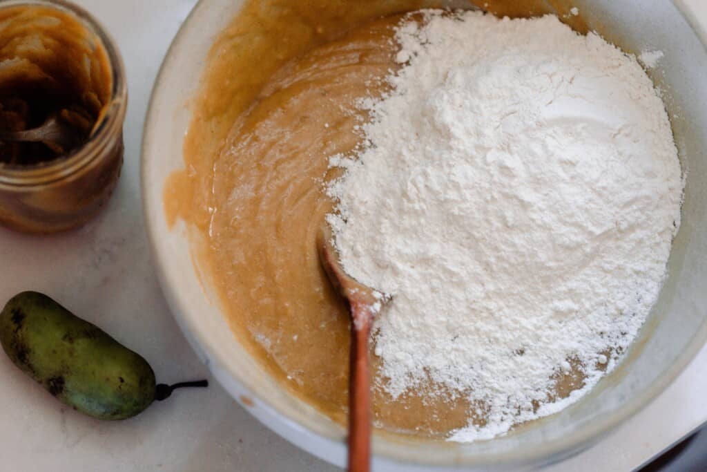 flour added to quick bread batter in a ironstone bowl 