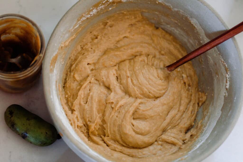 pawpaw bread batter in an ironstone bowl with a wooden spoon